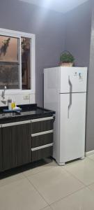 佩洛塔斯Casa Familiar Moradas Pelotas的厨房配有白色冰箱和窗户。