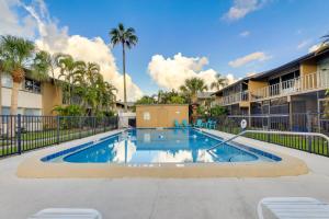 萨拉索塔Welcoming Sarasota Vacation Rental with Pool!的棕榈树公寓大楼庭院内的游泳池