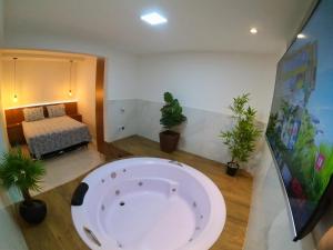 瓦拉达里斯州长市TH 101 - Flat com Banheira de Hidromassagem的盆栽室里的大浴缸