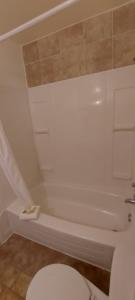 大福克斯Granby River Inn & Suites的白色的浴室设有卫生间和浴缸。