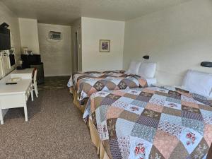 大福克斯Granby River Inn & Suites的酒店客房配有两张床和一张书桌