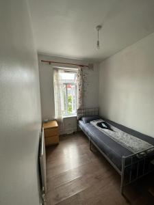 伦敦Affordable Private Rooms in Wembley的一间带床的卧室,位于带窗户的房间内