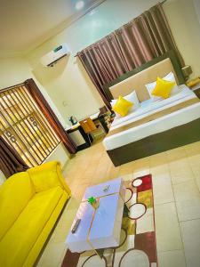 伊凯贾Posh Hotel and Suites Ikeja的一间卧室配有一张床、一张沙发和一张桌子