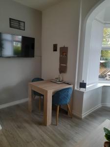 唐克斯特Flat 5 Corner House 1 bedroom的客房设有木桌和蓝色椅子。