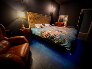Chazey-sur-AinLoveroom avec jacuzzi 01的一间卧室配有一张床、一把椅子和一盏灯