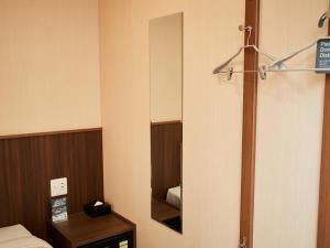 那霸Grand Cabin Hotel Naha Oroku - Vacation STAY 46864v的小房间设有镜子和一张床