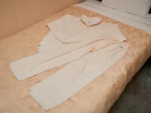 那霸Grand Cabin Hotel Naha Oroku - Vacation STAY 46864v的白色衬衫躺在床上