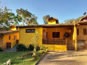 博西坎加Mandala casa 3 dorms cond fech piscina churrasqueira的一座黄色的房子,前面有一只狗