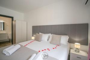 法兰西堡Carré d'as的卧室配有一张大白色床,上面有红色的弓