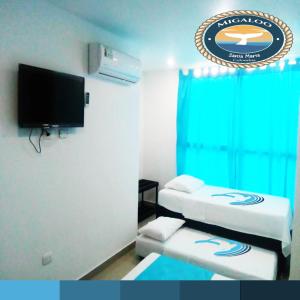 Puerto de GairaMigaloo Hostal Rodadero的酒店客房设有两张床和一台平面电视。