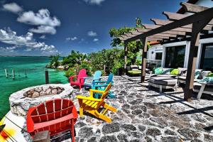 马尔斯港Harbour Beach Villa - large dock & great views!的一组椅子坐在海边的庭院里