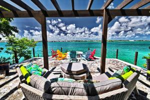 马尔斯港Harbour Beach Villa - large dock & great views!的海滩上带沙发和椅子的庭院