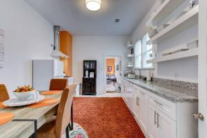 温泉城Clementine Bungalow Downtown Hot Springs的厨房配有白色橱柜和橙色地毯的桌子。