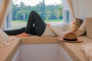 波哥大Campervan Bogota Rolling Suite的戴帽子的女人躺在窗边摇摆