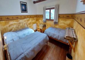 Yanque特拉迪逊科尔卡酒店的一间卧室设有两张床、一张桌子和一个窗口