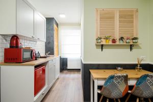 蒂米什瓦拉NEW Iorga4 OldCity SelfCheckIn的厨房配有白色橱柜和木桌