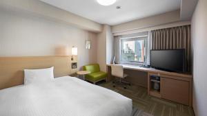 盛冈盛冈大和鲁内酒店的酒店客房配有一张床、一张书桌和一台电视。