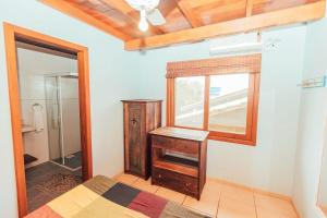 伊比拉奎拉Acomodações Ibirawave的一间卧室设有一张床、一个窗口和一面镜子