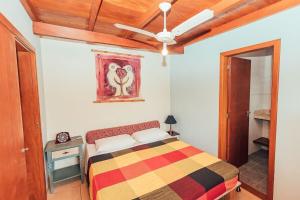 伊比拉奎拉Acomodações Ibirawave的卧室配有一张床,墙上挂有绘画作品