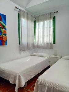 大加那利岛拉斯帕尔马斯Bungalow en el sur de Gran Canaria的白色墙壁客房的两张床