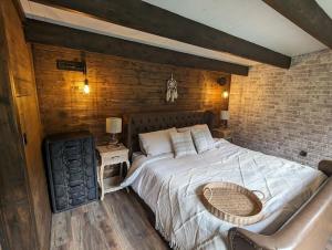 LymingeGorgeous countryside cabin的一间卧室设有一张大床和砖墙
