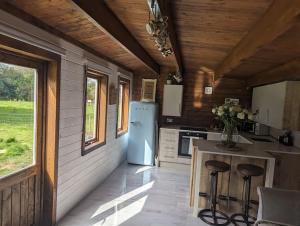 LymingeGorgeous countryside cabin的厨房配有冰箱和带凳子的台面