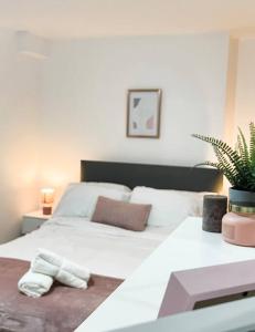 莱斯特Newly furnished Apartment, Leicester City Centre的卧室配有白色的床和植物