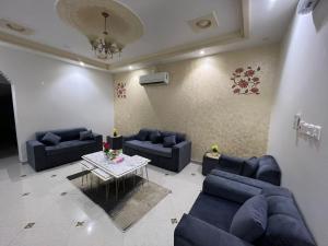 塔伊夫شقةكبيره 4 غرف منها 3 غرف نوم اطلاه مجلس صالة 4-room apartment, including 3 bedrooms, a living room, a sitting room, and a view的客厅配有蓝色的沙发和桌子