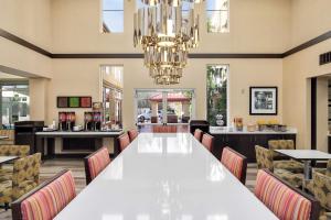林伍德西雅图北部/林恩伍德汉普顿套房酒店 的一间大型用餐室,配有一张白色的大桌子和椅子