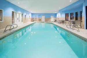 圣罗莎圣罗莎汉普顿酒店的一座拥有蓝色墙壁和桌椅的大型游泳池