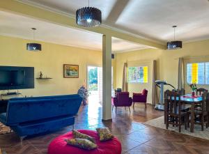 陶巴特Chacara com piscina, churrasq e WiFi em Taubate SP的客厅配有蓝色的沙发和桌子