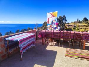 HuillanopampaTaquile Inti Raymi Lodge的坐在桌子上欣赏海景的人