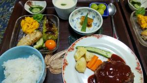 NiimiJapanese Style Inn Dohzen Miwa的盘子里放着米饭和蔬菜的食物