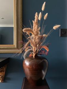 伦敦Luxury mid century Apartment的桌子上的一个花瓶,上面有植物