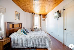 瓦尔帕莱索Hostal lala porteña vista al mar, baño privado y desayuno的一间卧室设有一张木天花板床。