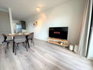 塞尔福斯New Selfoss Apartment - Stylish & Modern的客厅配有餐桌和电视