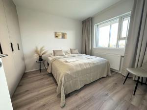 塞尔福斯New Selfoss Apartment - Stylish & Modern的白色的卧室设有床和窗户