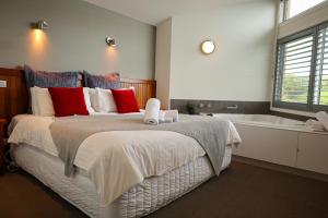 仙女港Tides Port Fairy的一间卧室设有一张大床和一个浴缸