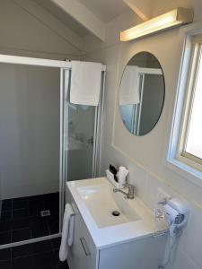 安特兰斯蓝礁湖海滩度假酒店的浴室配有盥洗盆和带镜子的淋浴