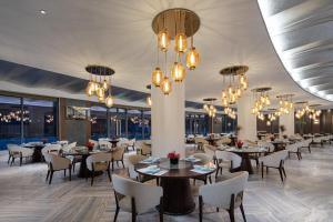 台州台州白天鹅酒店的用餐室配有桌椅和吊灯。