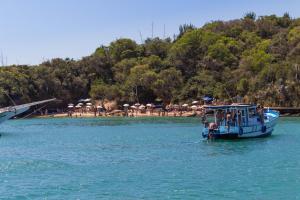 布希奥斯Búzios Centro Hotel的海滩附近的水域中的蓝色小船