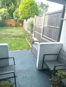 伦敦Walthamstow 1 bed的庭院设有两把椅子和围栏