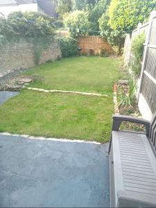 伦敦Walthamstow 1 bed的后院设有草坪和带围栏的院子