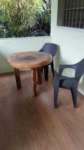 曼巴豪ACACIA'S Cottages mit Starlink Wifi的一张木桌、一把椅子、一张桌子和一把椅子