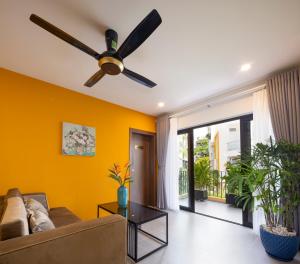 胡志明市Terracotta Villa Saigon的客厅配有吊扇和黄色墙壁。