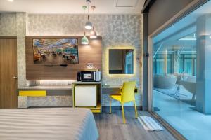 曼谷Qiu Hotel Sukhumvit SHA Plus的一间卧室配有一张床和一张带微波炉的书桌