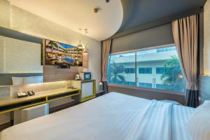 曼谷Qiu Hotel Sukhumvit SHA Plus的一间卧室设有一张大床和一个窗户。