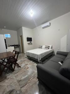 博阿维斯塔APARTAMENTO MOBILIADO的一间卧室配有一张床、一张沙发和一张桌子