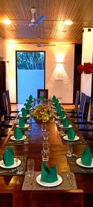 瓦伊卡尔Even Beach Resort的一张带绿色餐巾和眼镜的大长桌