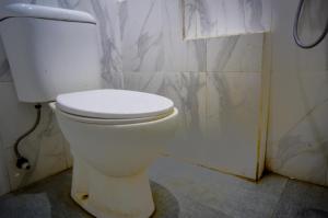 泗水OYO 93069 Penginapan Sumber Rizki的带淋浴的浴室内的白色卫生间